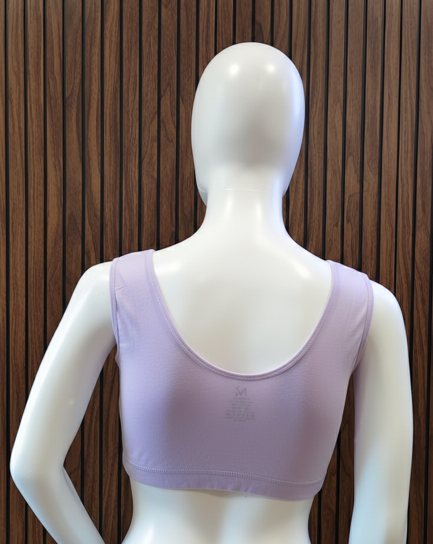 Mannequin wearing a purple sports bra against a wooden panel background